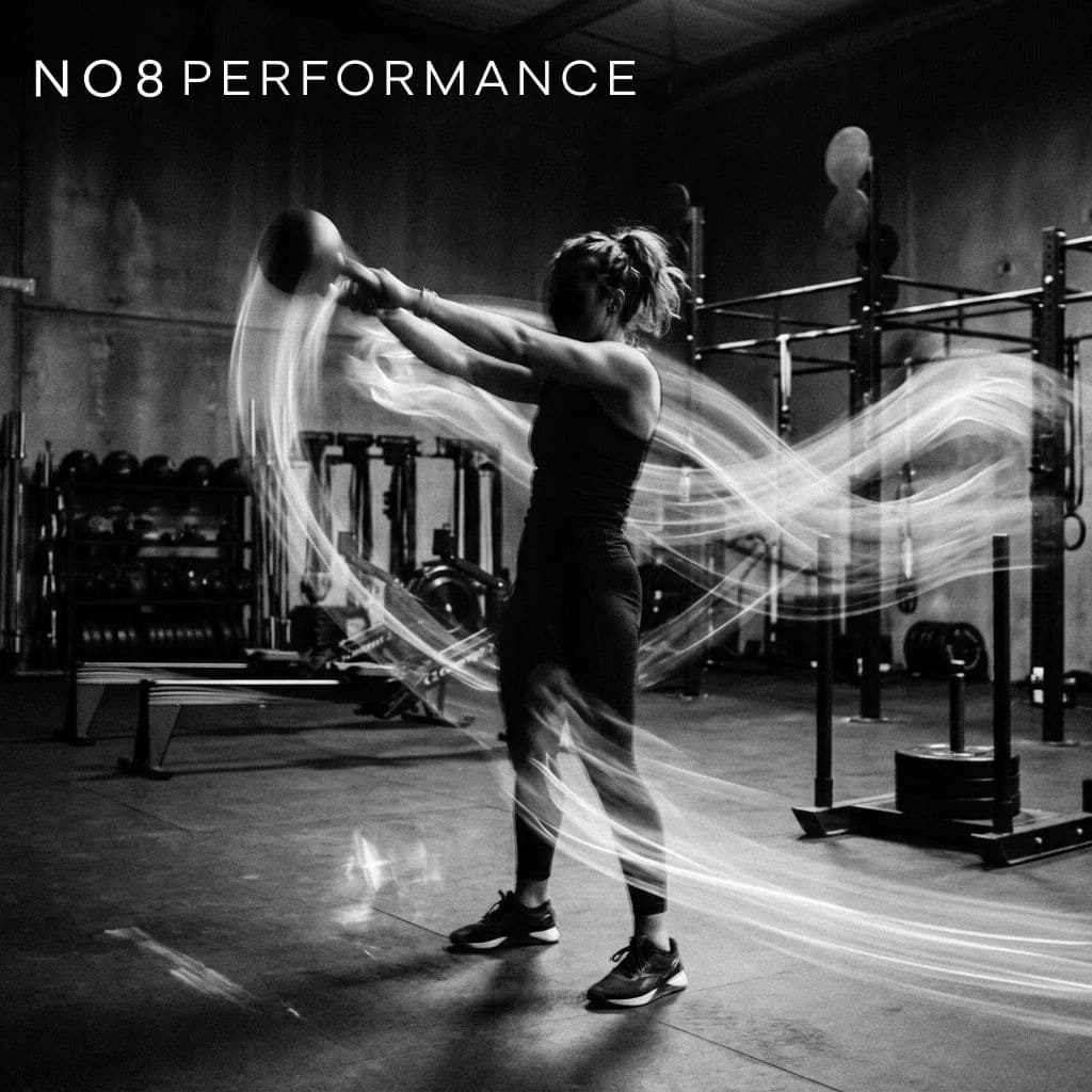 Kettlebell swing traced by a figure-eight light trail in a dark gym